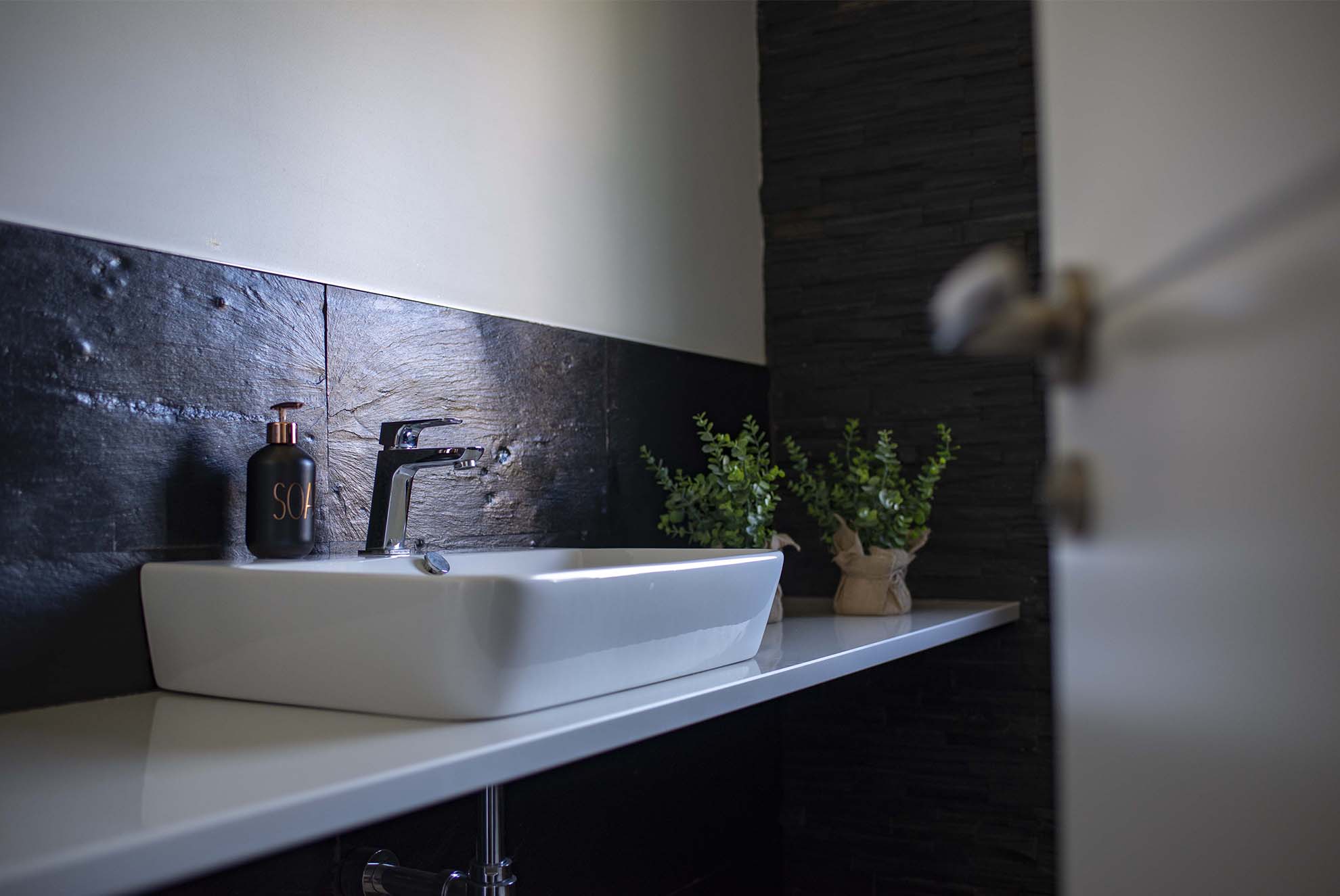Salle de bain schiste Infercoa Lavabo en ardoise naturelle en premier plan, avec une texture brute qui apporte élégance et authenticité à l'espace