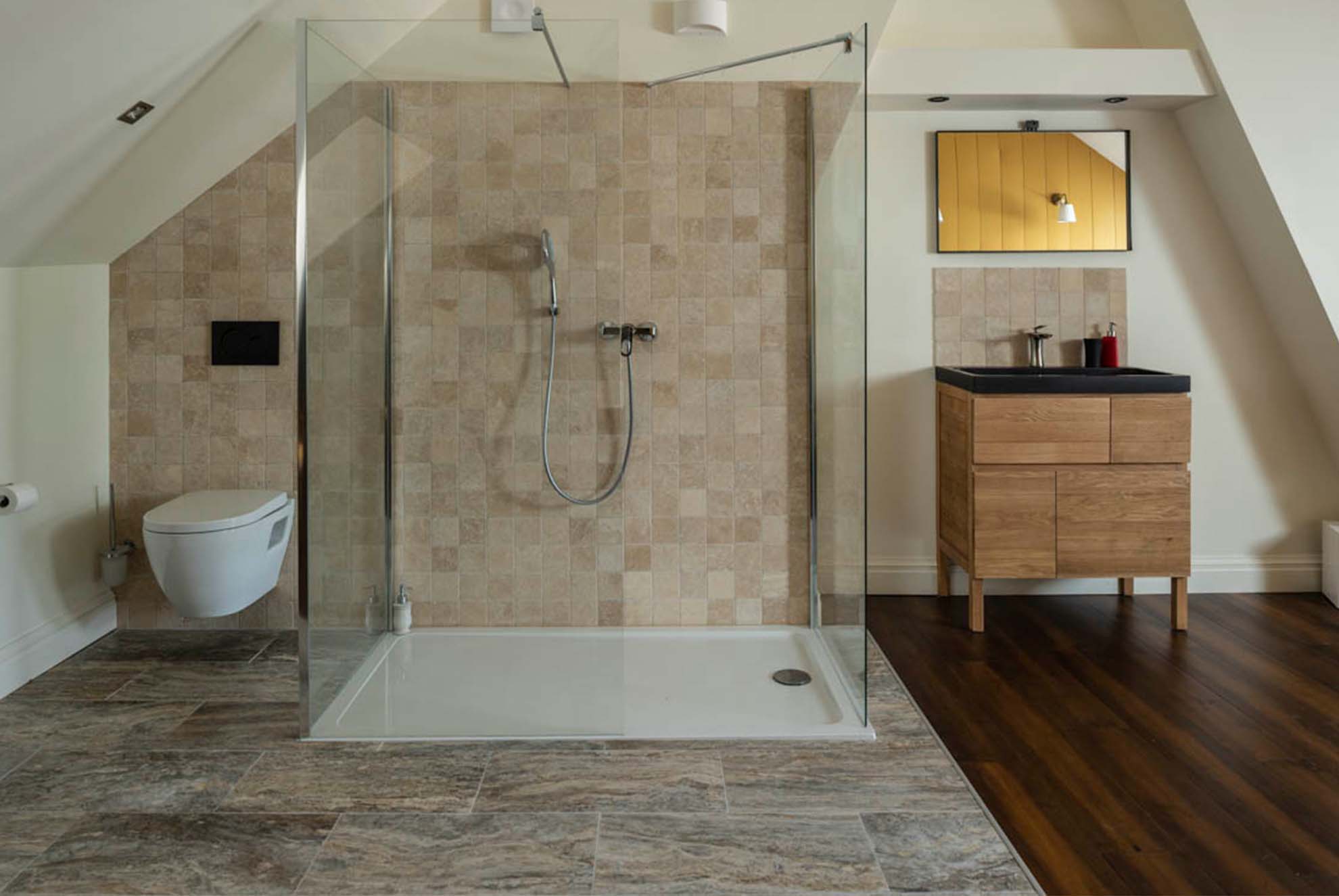 Salle de bains élégante avec des murs de douche revêtus de travertin. La texture chaleureuse et les nuances naturelles du travertin ajoutent une touche de sophistication, tout en créant une atmosphère luxueuse et apaisante.