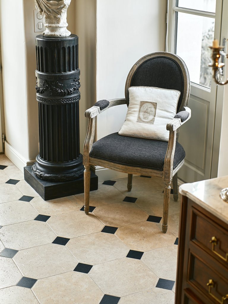 Sol en pierre naturelle calcaire Alhambra avec cabochons noirs, dans un intérieur de style classique restauré.