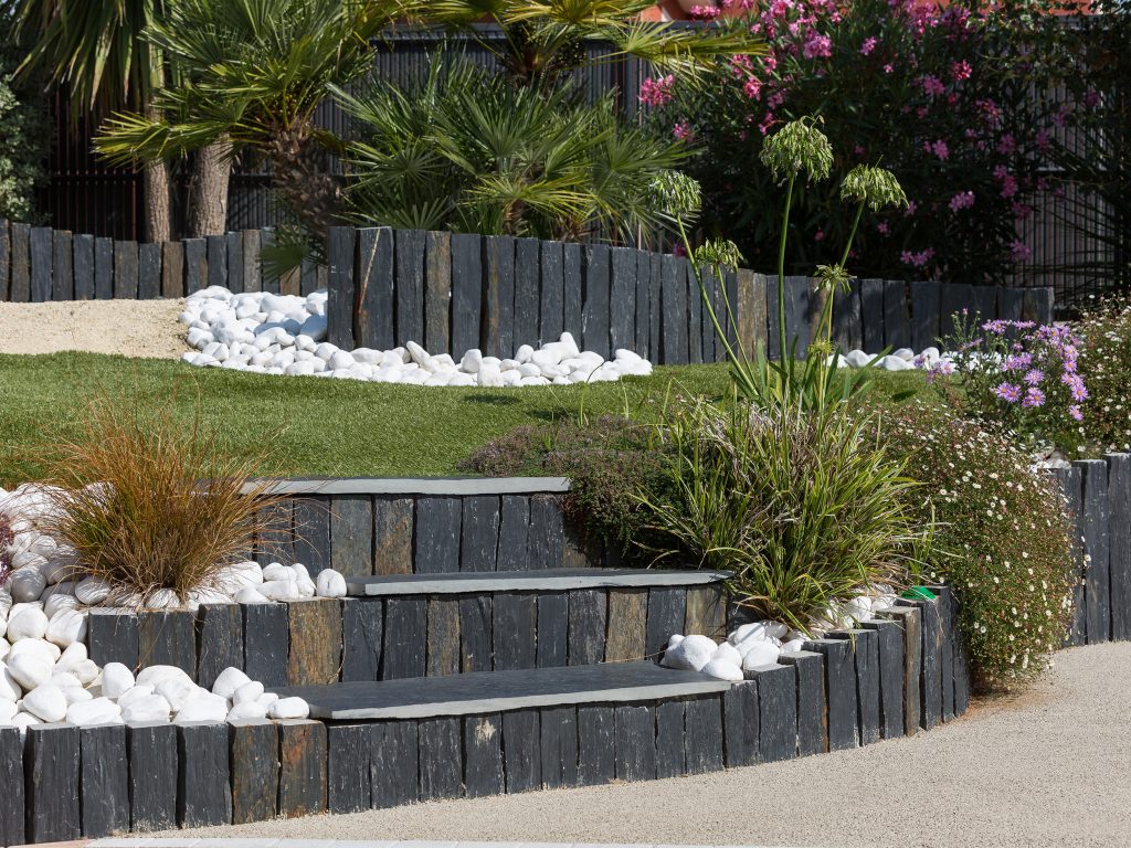 Les piquets Infercoa, de différentes hauteurs et disposés successivement, structurent le jardin tout en assurant le soutènement des terres.