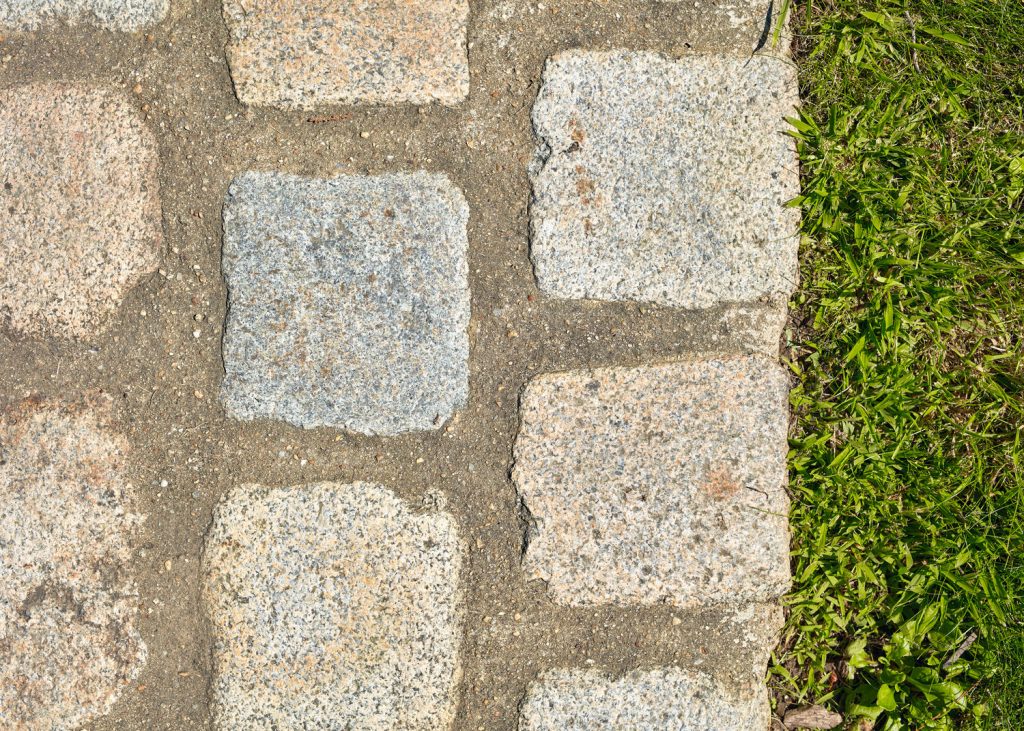 Un chemin en pavés de granit Beige Breton, où la robustesse de la pierre naturelle s’accorde avec la douceur du jardin.