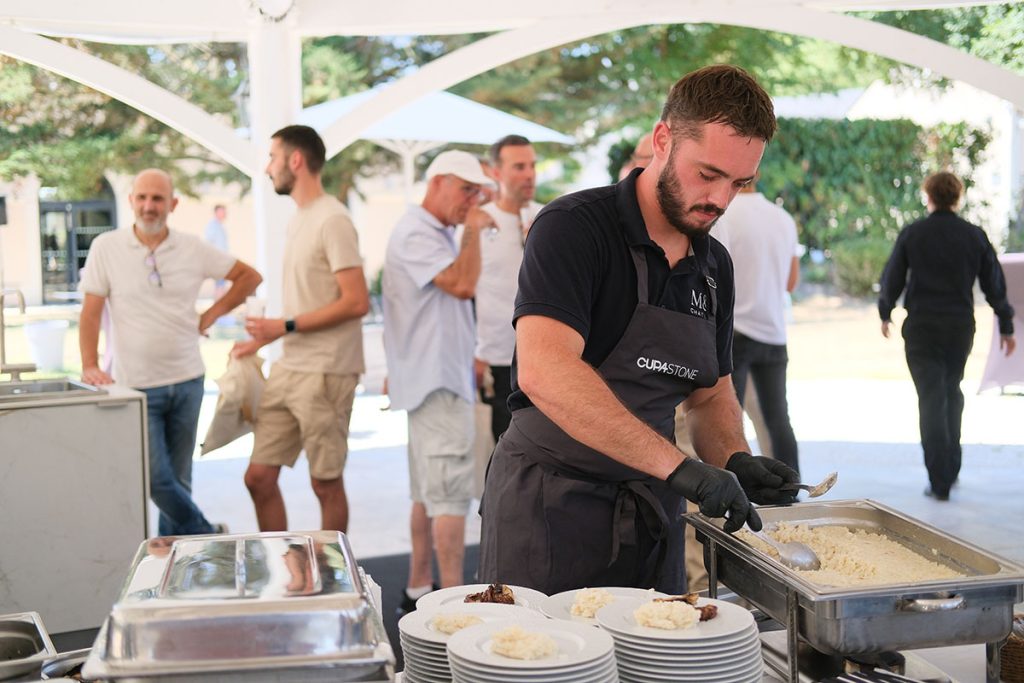 Chef préparant un buffet sur un îlot de cuisine extérieure modulaire en Ceratop®, lors d'un événement de présentation